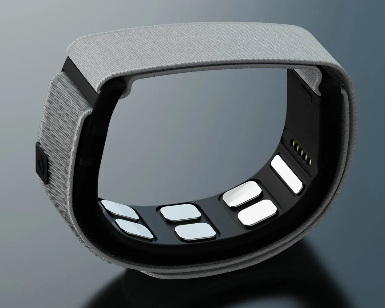 the grey fabric wristband from the side, showing the black sensor plate and its four electrode pads, on a dark reflective surface.