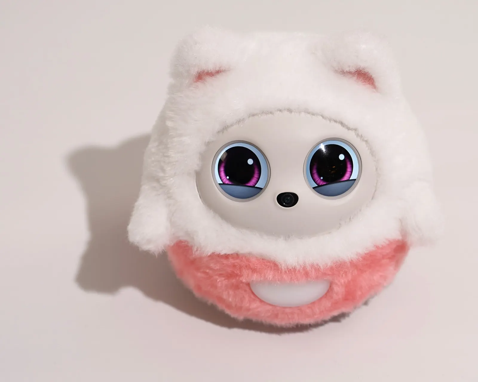 InsBotics press photograph: Pophie in the standard white Kitty outfit facing the camera, two round LCD eyes above a pink plush belly.